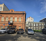 Здание в центре с большой парковкой.
