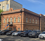 Здание в центре с большой парковкой.