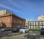 Здание в центре с большой парковкой.